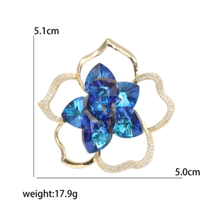 Elegant gold camellia brooch with blue crystal heart petals and white zircons