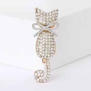Close-up of elegant cat brooch featuring white rhinestones and silver bow detail