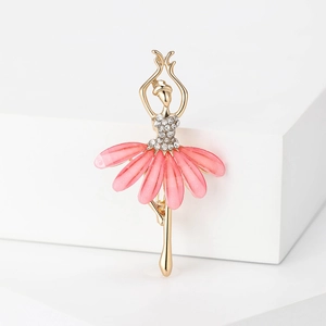 Détail d'une élégante broche ballerine dorée avec cristaux et pétales de fleurs roses