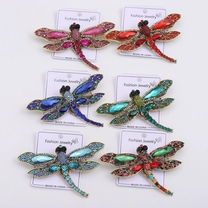 Detail view of colorful dragonfly brooches set with rhinestones on display cards