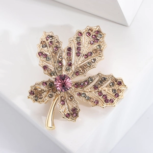 Exquisite gold maple leaf brooch with purple rhinestones and central faceted crystal gem