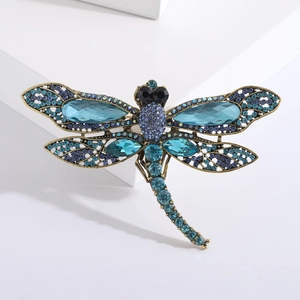 Detail of dragonfly brooch with blue rhinestones on a vintage gold metal base
