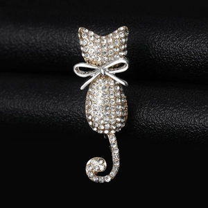 Macro view of sparkling rhinestone cat brooch with gold alloy base and silver bow detail