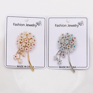 Macro detail of dandelion floral brooches with colorful rhinestones on display card