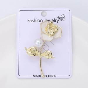 Detail of camellia flower brooch with gold plating, white enamel, and a single pearl inlay
