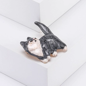 Broche chat gris et blanc s'étirant avec motif marbré sur un fond blanc minimaliste