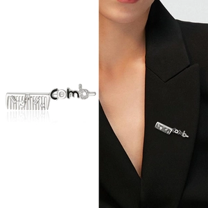 Detailed view of silver comb brooch with rhinestones pinned on a black suit lapel
