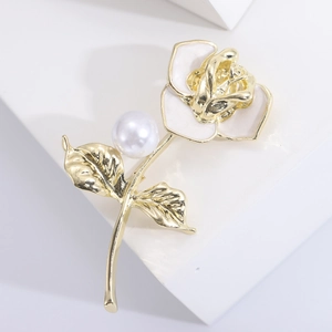 Elegant gold rose brooch with white enamel petals and a large round pearl accent