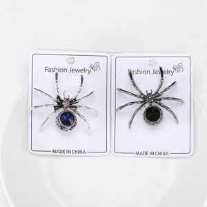 Detail of creative spider brooches with blue and black rhinestones on display cards