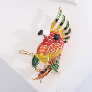 Detail of colorful parrot brooch with enamel feathers and sparkling black gemstone eye