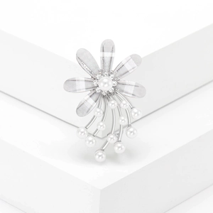Elegante weiße Blumenbrosche mit Perle und Quasten auf einem minimalistischen Display