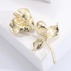 Elegant gold camellia flower brooch with pearl accent and secure pin back detail