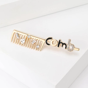 Close-up of creative comb brooch with gold plating and sparkling white rhinestones
