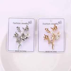Détail des broches fleur et papillon avec perles blanches et zircons cubiques brillants
