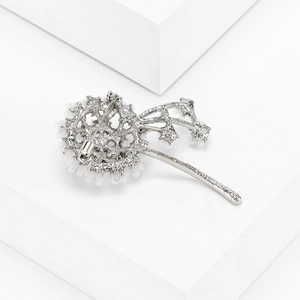 Detail of flower brooch with white bead petals and silver pin buckle on back