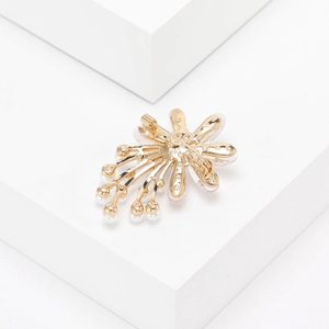 Detailansicht der Rückseite der goldenen Blumenbrosche mit Sicherheitsnadel und Perlen