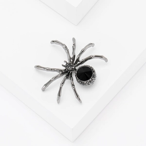 Macro detail of gothic black spider brooch with faceted gemstone and pavé rhinestones