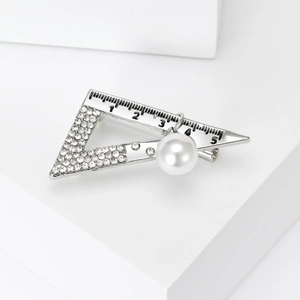 Detailed view of alloy triangle ruler brooch with rhinestones and hanging pearl charm