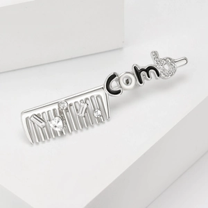 Detailed view of silver comb brooch with rhinestones and black and white enamel art