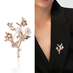 Broche fleur papillon dorée élégante avec perles et cristaux sur tailleur noir