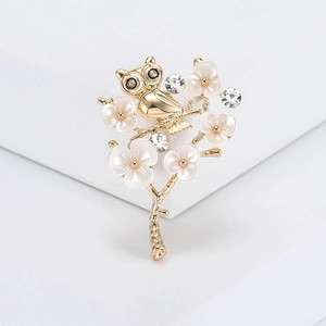 Elegant gold owl brooch on flowering plum branch with crystals for suits and coats