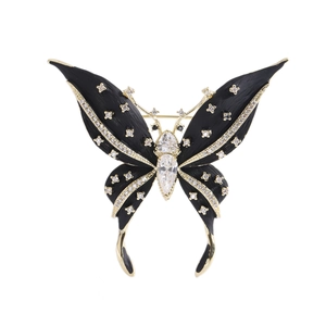 Elegante spilla a farfalla in oro con smalto nero e accenti di zircone su sfondo bianco