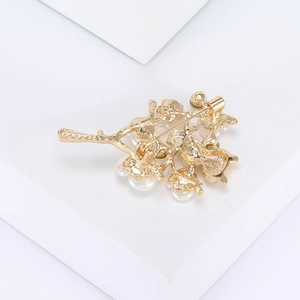 Detailed back view of golden owl branch brooch showing pin clasp and metal structure