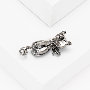 Detail view of the back of a crystal cat brooch showing the secure pin clasp and metal alloy texture