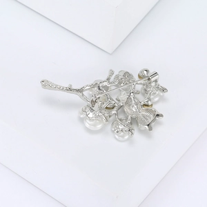 Detailed view of the silver owl brooch back pin fastening and elegant branch design