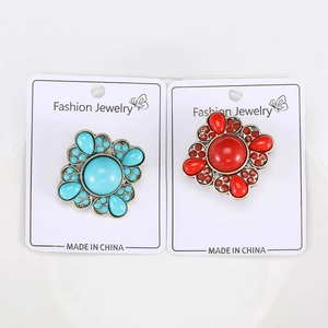 Detailed view of vintage bohemian flower brooches with blue and red gemstone inlays
