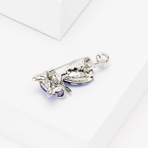 Close-up detail of silver cat brooch featuring dark blue crystals and secure pin clasp