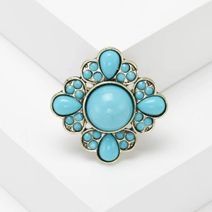 Vintage bohemian gold brooch with turquoise blue stones in a floral symmetrical pattern