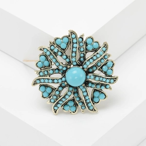 Vintage flower brooch featuring turquoise beads and antique gold finish floral design