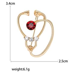 Golden stethoscope brooch with red crystal and dimension marks 3.4cm by 2.5cm
