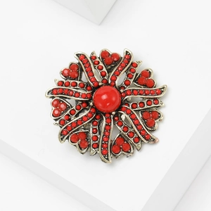 Detail of vintage red sunflower brooch with antique gold metal petals and bead clusters