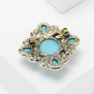 Macro view of vintage gold finish brooch back with blue stones and metal pin fastener