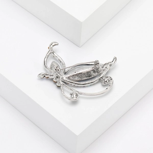 Detailed back view of silver butterfly brooch showing pin fastener and metallic texture