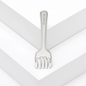 Creative melting fork brooch in stainless steel with engraved handle on white background