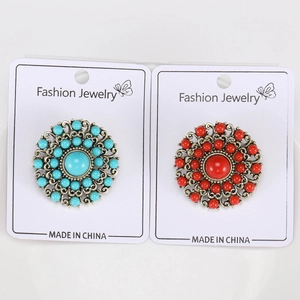 Detailed macro view of vintage baroque brooches with turquoise and red beads on gold base