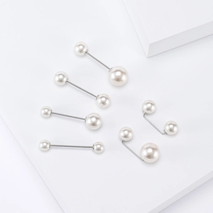 Detail view of various sizes of pearl safety pins and brooches for sweaters and shirts