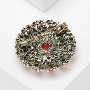 Close-up of vintage baroque brooch back showing the secure pin clasp and antique gold finish