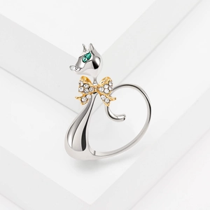 Bague chat mignonne en argent avec yeux en cristal vert et nœud en diamant doré sur blanc