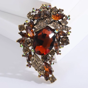 Detailed macro view of vintage baroque brooch with amber gemstones on antique gold base
