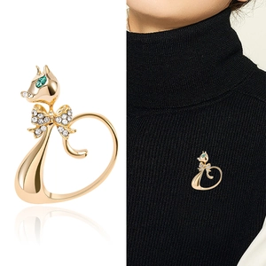 Broche chat dorée élégante avec œil en pierre verte et nœud en strass sur tricot