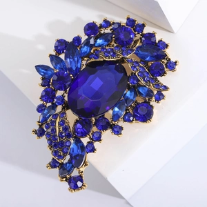 Close-up of vintage royal blue crystal brooch with intricate gold alloy base detailing