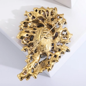 Detailed back view of vintage alloy brooch with antique gold texture and metal pin