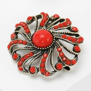 Detailed macro of vintage bohemian brooch with red gemstones and antique gold texture