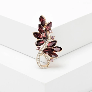Eleganter Blatt-Brosche mit lila und rosa Kristallen auf minimalistischen Stufen