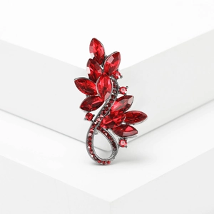 Eleganter Blumenbrosche mit tiefroten Kristallen auf Vintage-Silber auf weißen Stufen