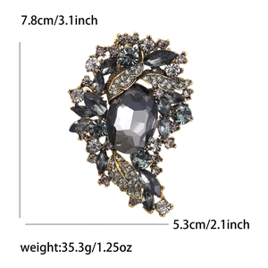 Vintage gold alloy brooch with grey crystals and rhinestones in an elegant oval design